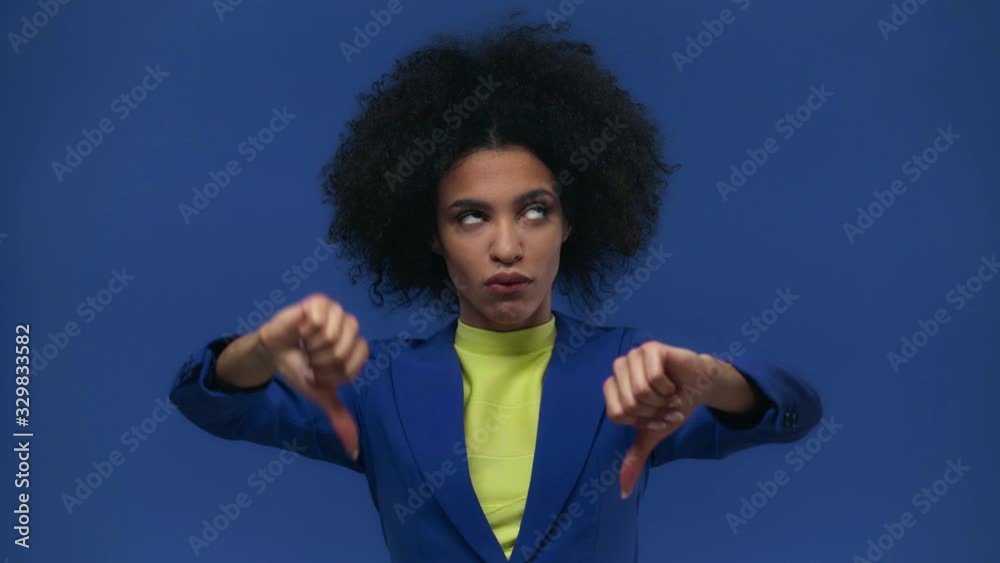 african american girl showing thumbs down isolated on blue african american girl showing thumbs down isolated on blue