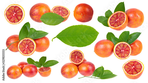 Set of sliced and unpeeled ripe blood oranges with green leaves isolated on white background