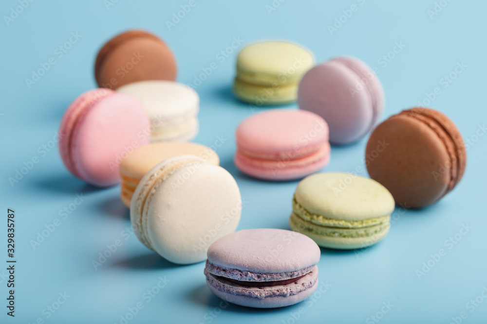 Macaroni cookies of different colors are scattered on a blue background. Macaroni cookies of different colors are scattered on a blue background.