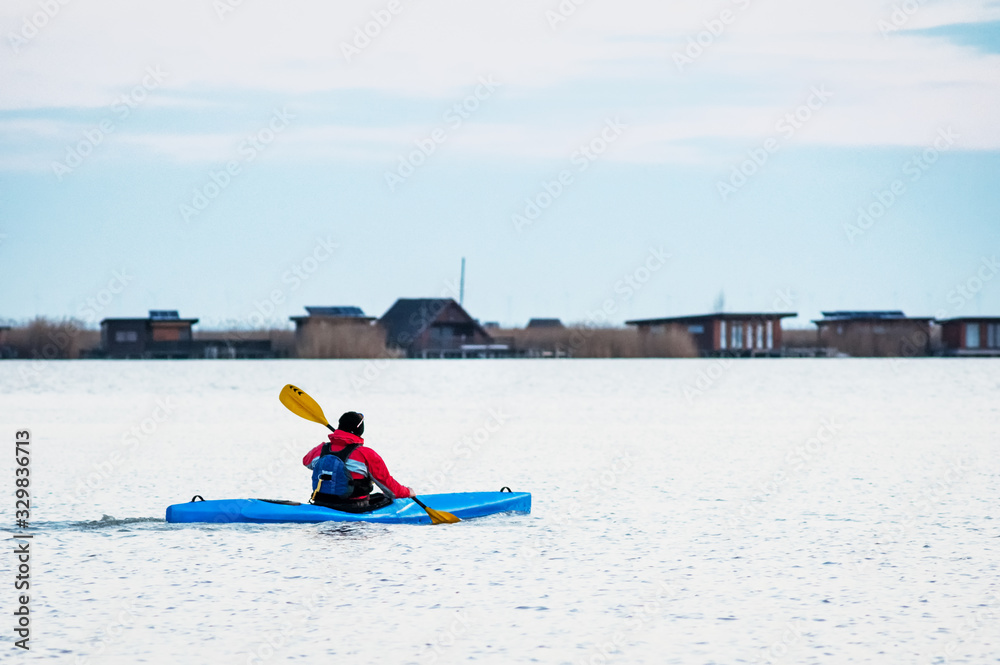 Naklejka premium Man with kayak on lake neusiedlersee in Burgenland