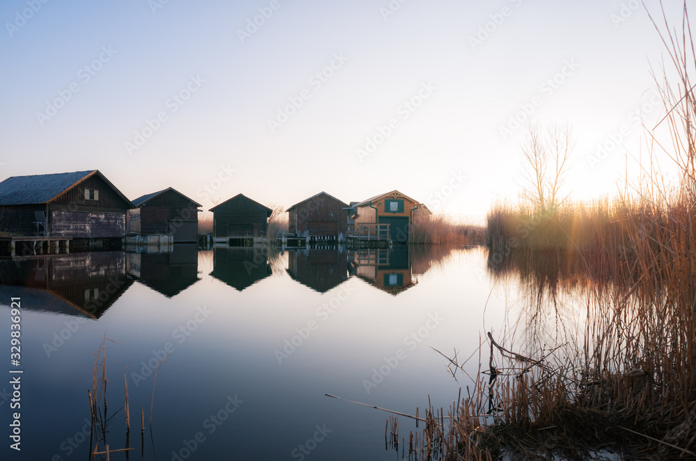 Obraz premium Log cabins on a canal at lake Neusiedlersee in Burgenland