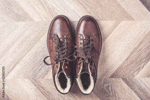 Top view of winter warm fashion male shoes on wooden background. Sale and shopping concept. Copy space.