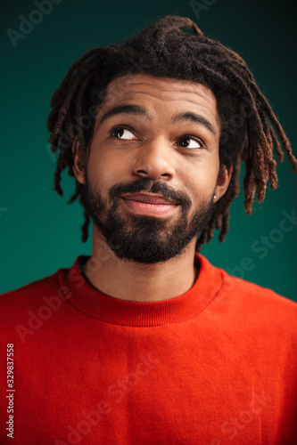 Portrait of pleased african american man posing and looking upward