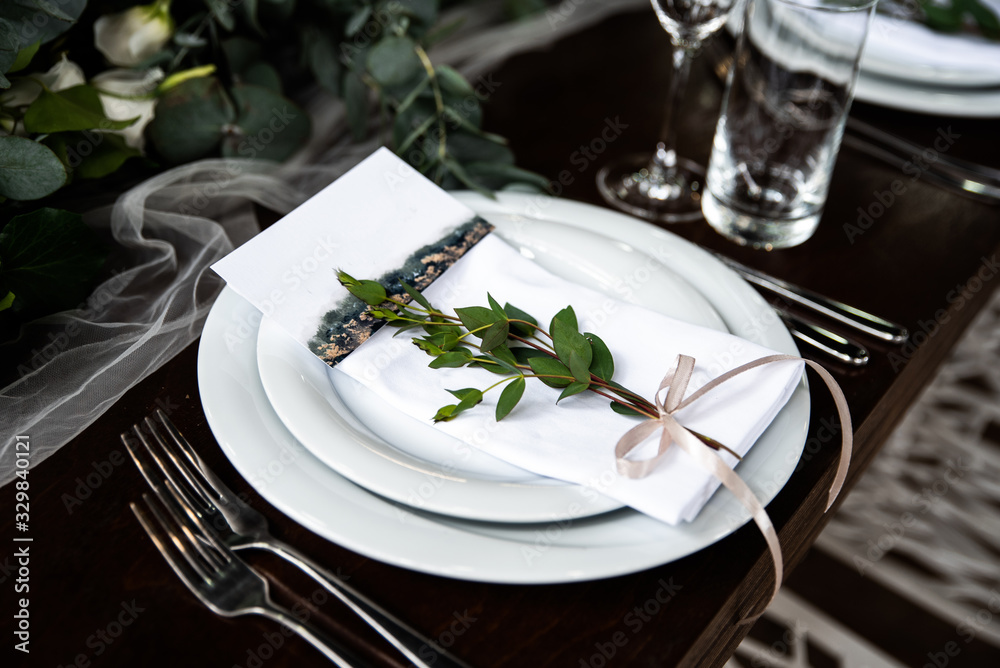 White napkin with eucalyptus and guest card on it White napkin with eucalyptus and guest card on it