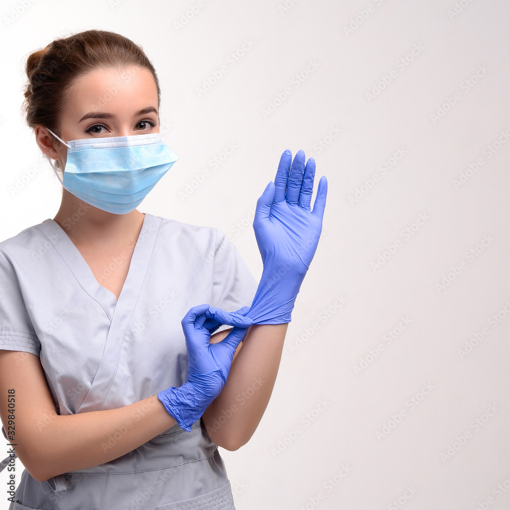 Beautiful female doctor or nurse wearing protective mask and latex or rubber gloves on white background isolated with copyspace. Health care concept Beautiful female doctor or nurse wearing protective mask and latex or rubber gloves on white background isolated with copyspace. Health care concept