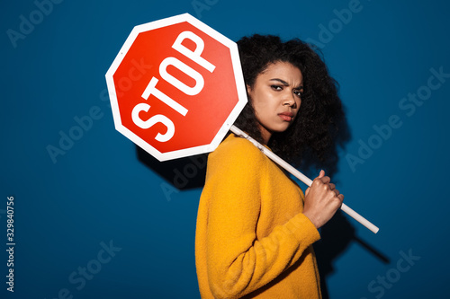 Displeased african woman holding stop symbol sign.