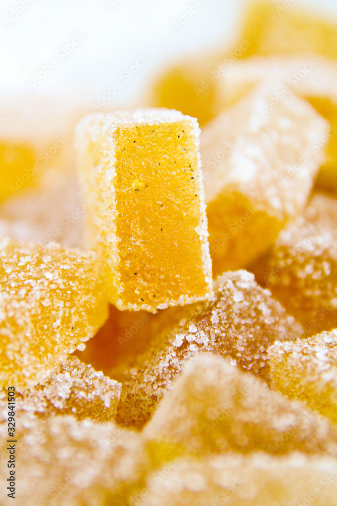 Pineapple, lemon, vanilla pate de fruit (jelly, marmalade, fruit candy) covered with sugar. White background, back view. There is a sliced jelly on a photo to show a texture inside of pate de fruit. Pineapple, lemon, vanilla pate de fruit (jelly, marmalade, fruit candy) covered with sugar. White background, back view. There is a sliced jelly on a photo to show a texture inside of pate de fruit.