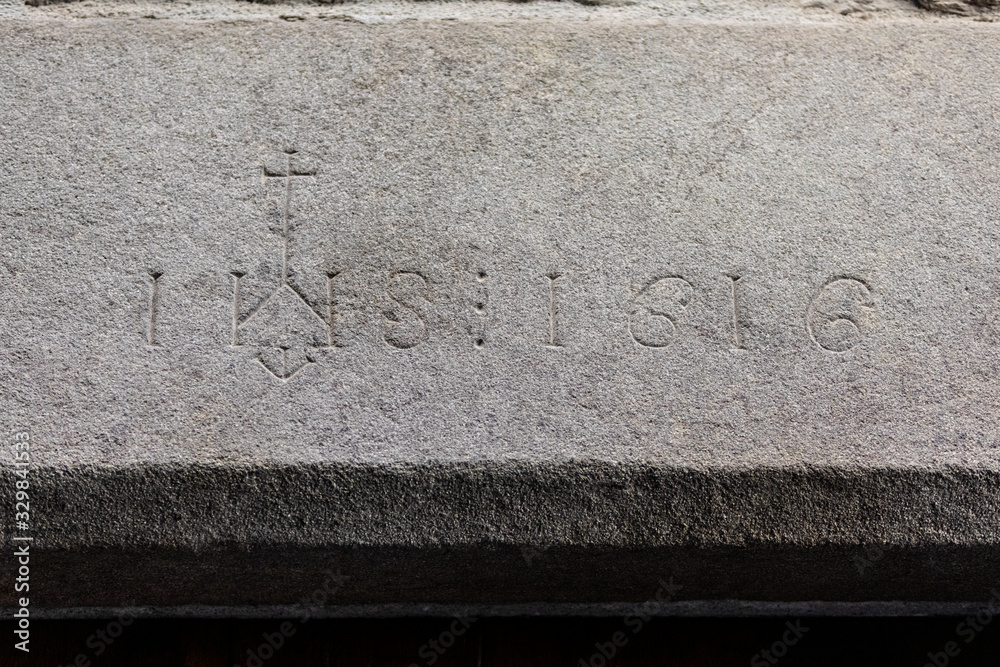 Dintel de piedra en Rupit (Osona, Barcelona, Catalunya) con la inscripción IHS (Iesus Hominum Salvator) y el número 1616