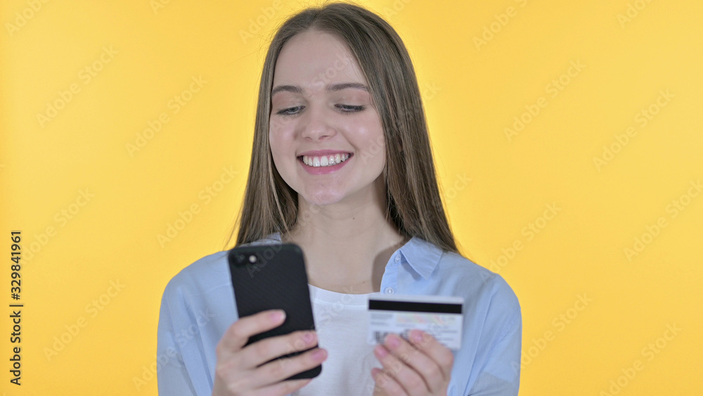 Online Payment on Smartphone by young Woman, Yellow Background Online Payment on Smartphone by young Woman, Yellow Background