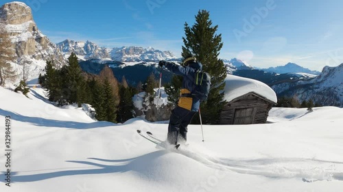 FOLLOW CLOSE UP: Happy skier having fun skiing backcountry on a sunny winter day in snowy mountains. Extreme freeride skier riding fresh powder snow off piste in mountain ski resort in dolomites Italy