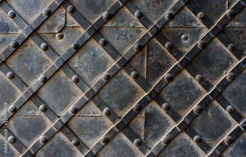 Black forged door, rhombus symmetrical texture. Grunge black background