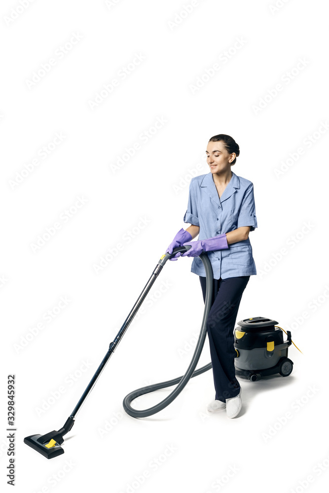 Young beautiful woman in a maid costume smiling and getting ready for vacuuming, isolated on a white background. Young beautiful woman in a maid costume smiling and getting ready for vacuuming, isolated on a white background.