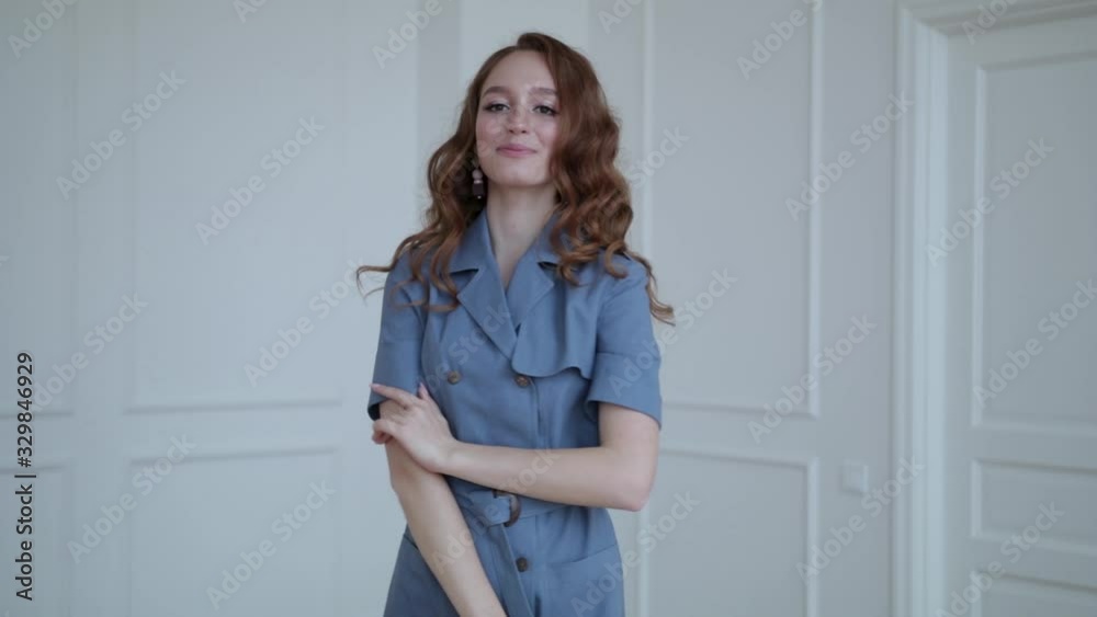 girl with red hair wearing a beautiful dress, white wall background, slow motion girl with red hair wearing a beautiful dress, white wall background, slow motion