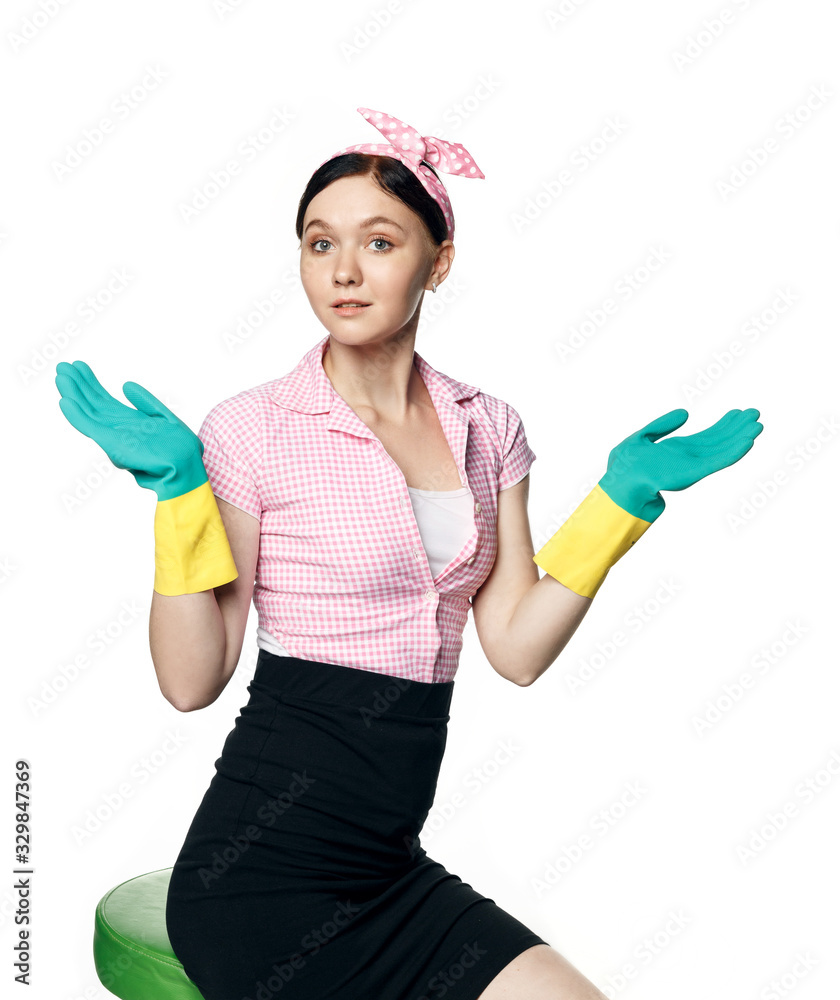 Beautiful pin-up girl in a pink shirt with rubber gloves for cleaning smiling broadly, arms spread side to side, palms up, isolated on a white background. Beautiful pin-up girl in a pink shirt with rubber gloves for cleaning smiling broadly, arms spread side to side, palms up, isolated on a white background.
