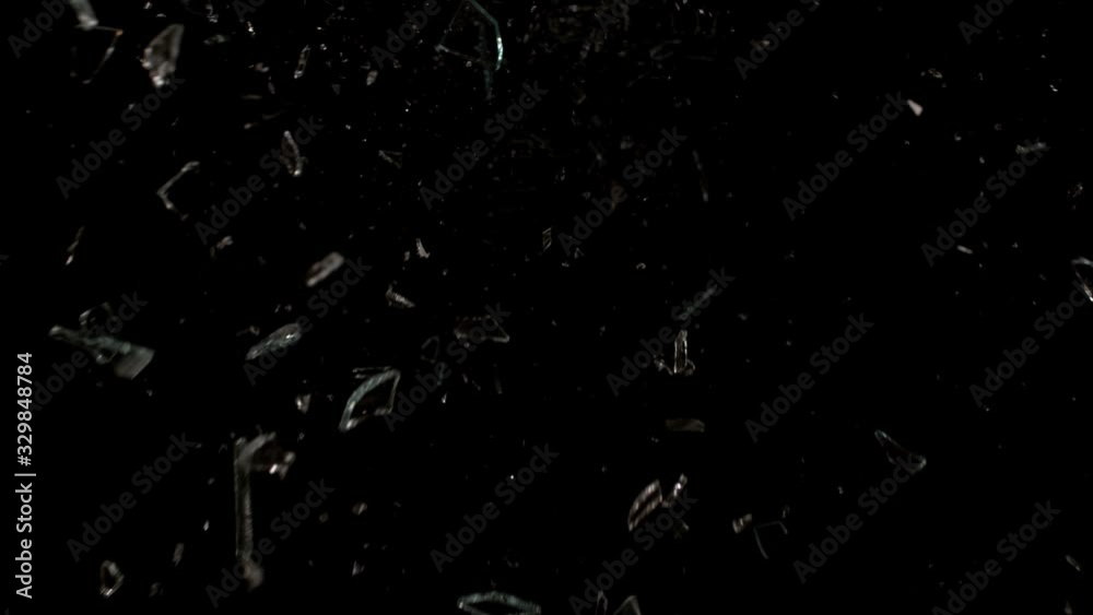 Glass breaking in slow motion on black background