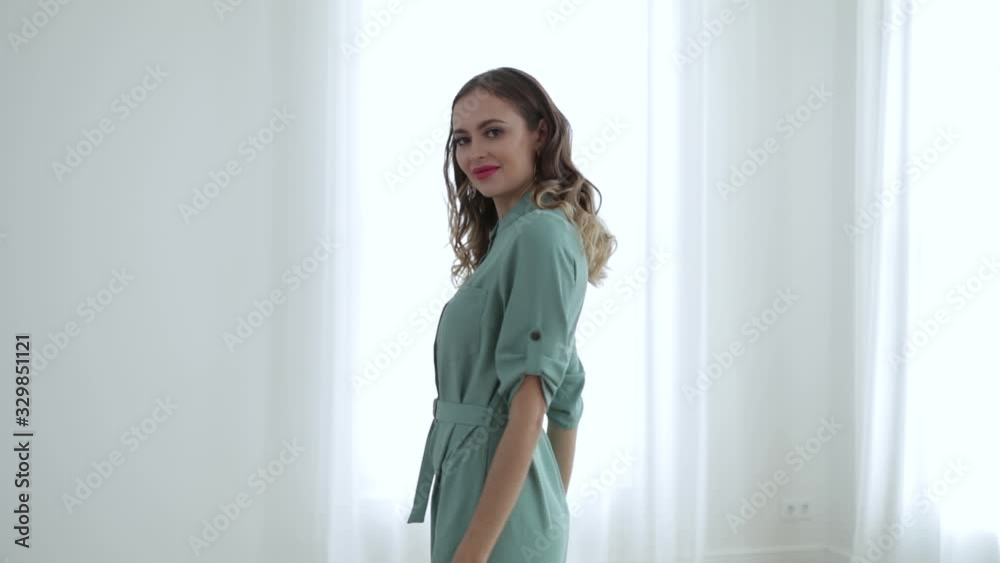 girl in grey coat and smiling, stroking her hair, the white background wall girl in grey coat and smiling, stroking her hair, the white background wall