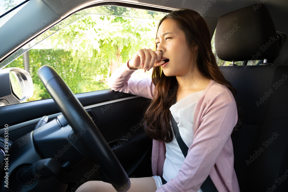 Young Asian woman hold her nose because of bad smell dirty in car Young Asian woman hold her nose because of bad smell dirty in car