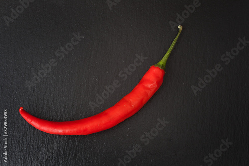 A red chilli pepper against a black background