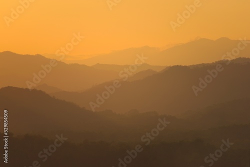 Orange sky over hazy mountains around Luang Prabang, Laos. View from the top of Mount Phou Si.