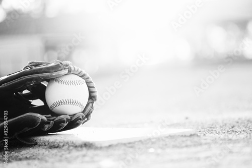 Photography baseball and glove on ball field in black and white with copy space for sports seasno