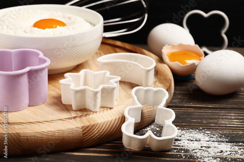 Baking utensils and ingredients. rolling pin, cookie mold,. cupcake cases and sugar sprinkling on a wooden background. Easter concept.