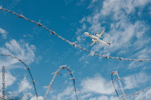 Image of Airplane taking off and barbed wire. Representing flight restrictions. 