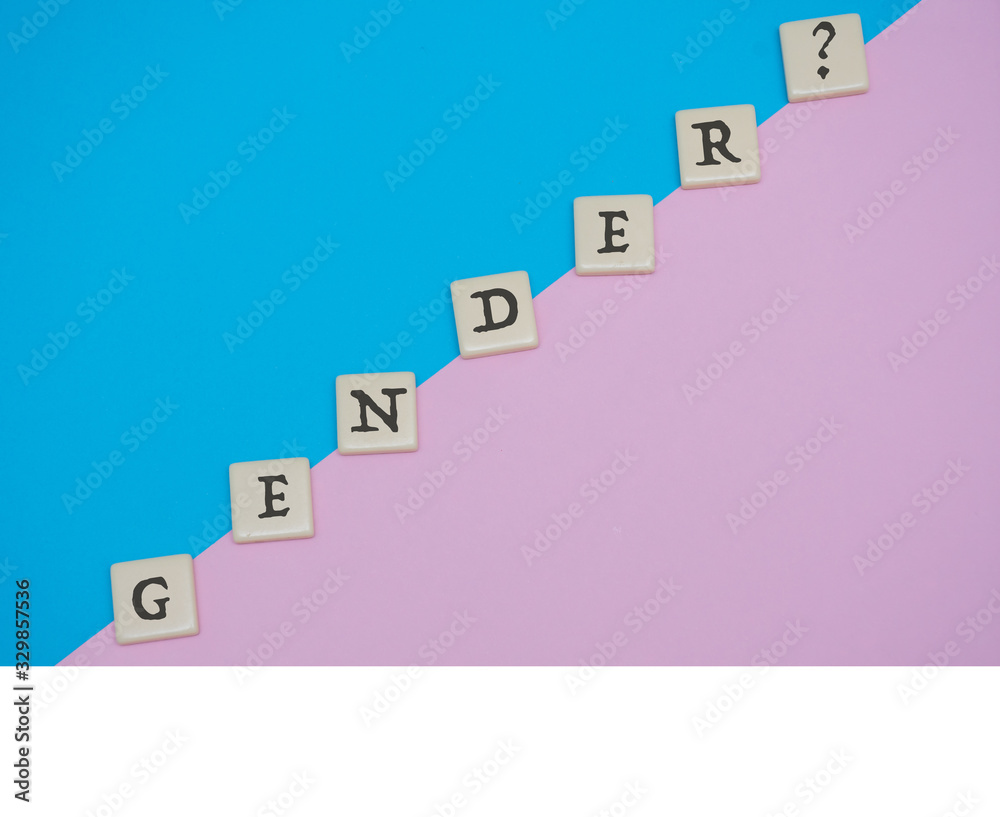 Gender tile letter flat lay on blue and pink colored background for theme of guessing gender of a baby or gender identify. - obrazy, fototapety, plakaty 