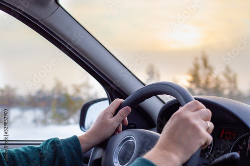 man drives a car on a winter road at dawn