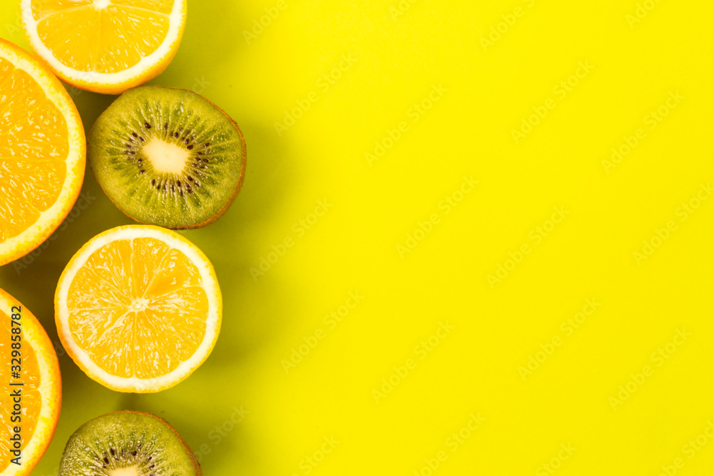 Fruit frame. Colorful fresh citrus fruits on a light green background. Orange, tangerine, lemon and kiwi are cut in half. Flat lay, top view, copy space. Fruit frame. Colorful fresh citrus fruits on a light green background. Orange, tangerine, lemon and kiwi are cut in half. Flat lay, top view, copy space.