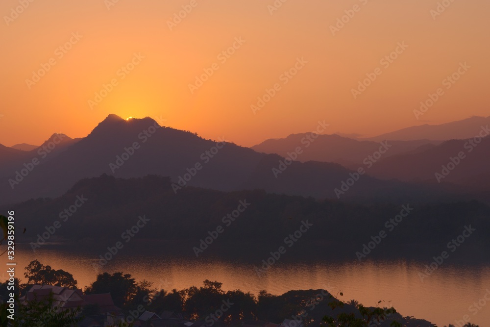 Sunset over the Mekong river and hazy mountains. View from Mount Phou Si, in Luang Prabang, Laos.