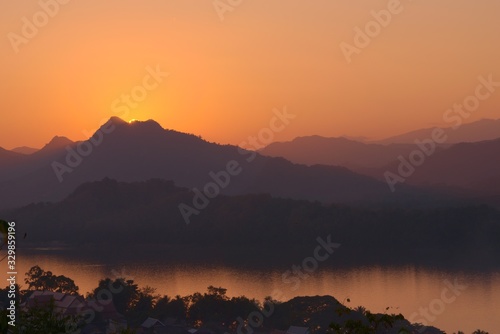 Sunset over the Mekong river and hazy mountains. View from Mount Phou Si, in Luang Prabang, Laos.
