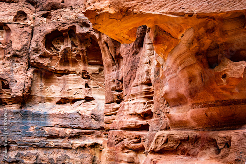 Natural rocky cascades of red sandstone in sunny land of Petra, Jordan