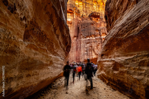 Group of people between sandstone rocks at narrow path in Petra, Jordan photo
