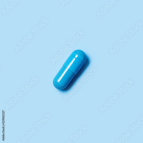 One blue capsule. Pills for men's health and sexual energy on an isolated background. Concept of erection, potency. Treatment of male infertility and impotence. Copy space