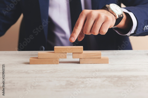 businessman shows finger on a wooden cube