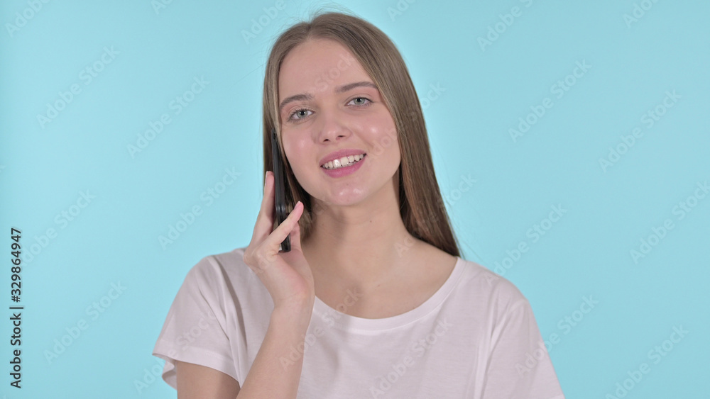 Beautiful Young Woman Talking on Smartphone , Blue Background Beautiful Young Woman Talking on Smartphone , Blue Background