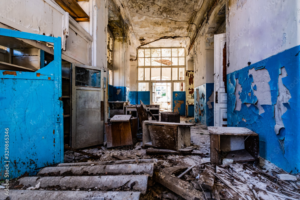 Ruined corridor with piles of garbage in abandoned building