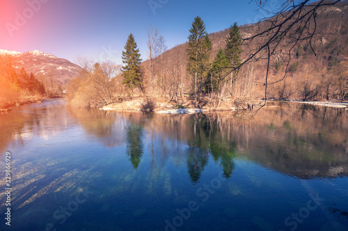 Alpine landscape in early spring on a sunny day. Mountain river Sava Bohinjka near Polje village. Beautiful nature of Slovenia, Europe photo