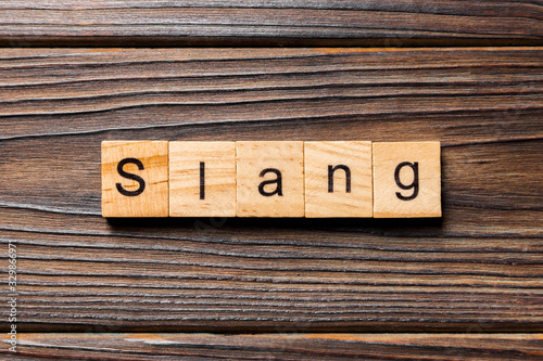 slang word written on wood block. slang text on table, concept photo