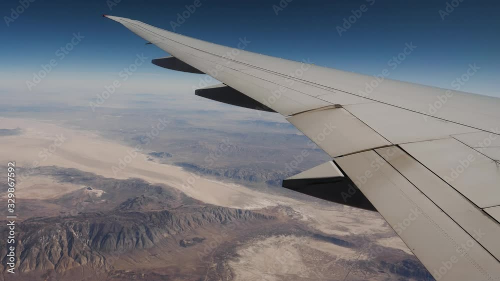 View Wing And Desert With Rock Formations From Window Of Plane Flying Altitude View Wing And Desert With Rock Formations From Window Of Plane Flying Altitude