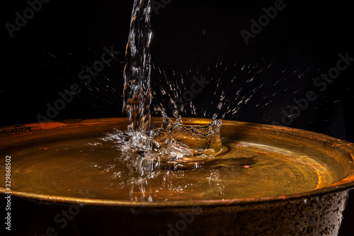 A stream of water flows into the copper wash basin