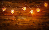 Garland in the form of hearts on wooden background