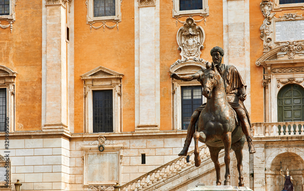 Rome Italy. Bronze statue of Roman Emperor Marcus Aurelius on steed at Capitol square among vintage buildings with ancient architecture.