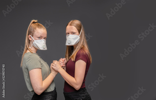  Studioaufnahme Corona Virus  - 2 deutsche Teenanger mit FFP3 Atemschutzmasken vor grauem Hintergrund photo