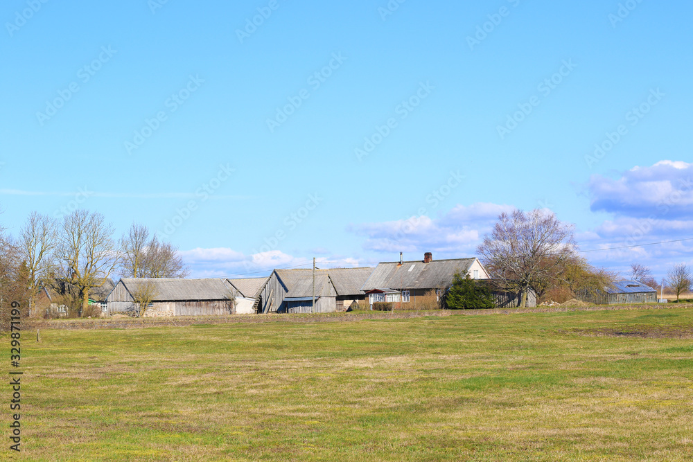 old farm houses with blue sky and clouds