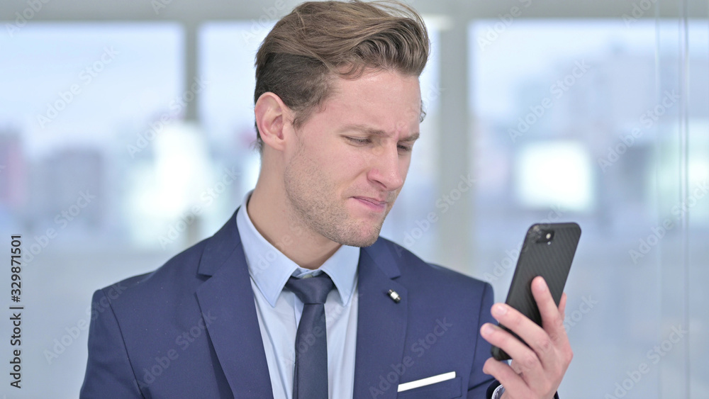 Portrait of Cheerful Young Businessman Celebrating on Smartphone Portrait of Cheerful Young Businessman Celebrating on Smartphone