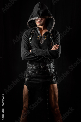 Young roleplayer posing in hooded gothic clothes with crossed arms © Florian Graf