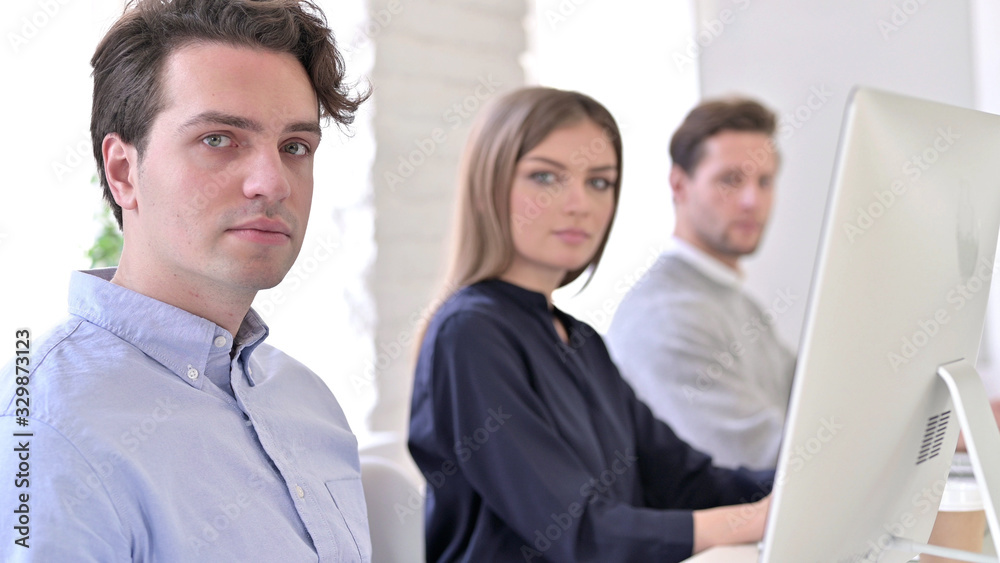 Serious Creative Team Looking at the Camera in Office Serious Creative Team Looking at the Camera in Office