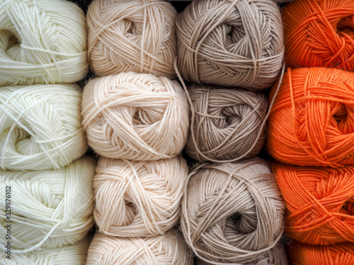 Multi-colored orange, beige, gray woolen threads in balls