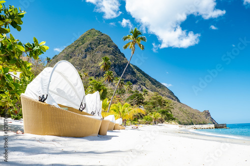 Sugar beach Saint Lucia , a public white tropical beach with palm trees and luxury beach chairs on the beach of the Island St Lucia Caribbean